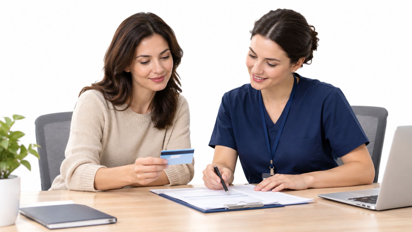 A patient holding a credit card as a medical professional assists with insurance documentation in an office.